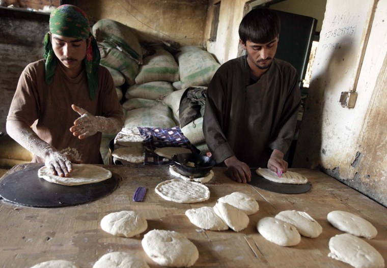 Image: Bakers knead bread dough outside FOB Clark in Khowst province